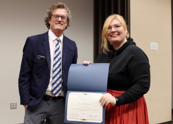 Man presenting a woman an award.