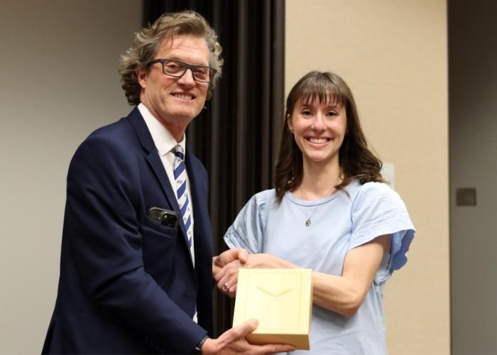 A man presenting an award to a woman.